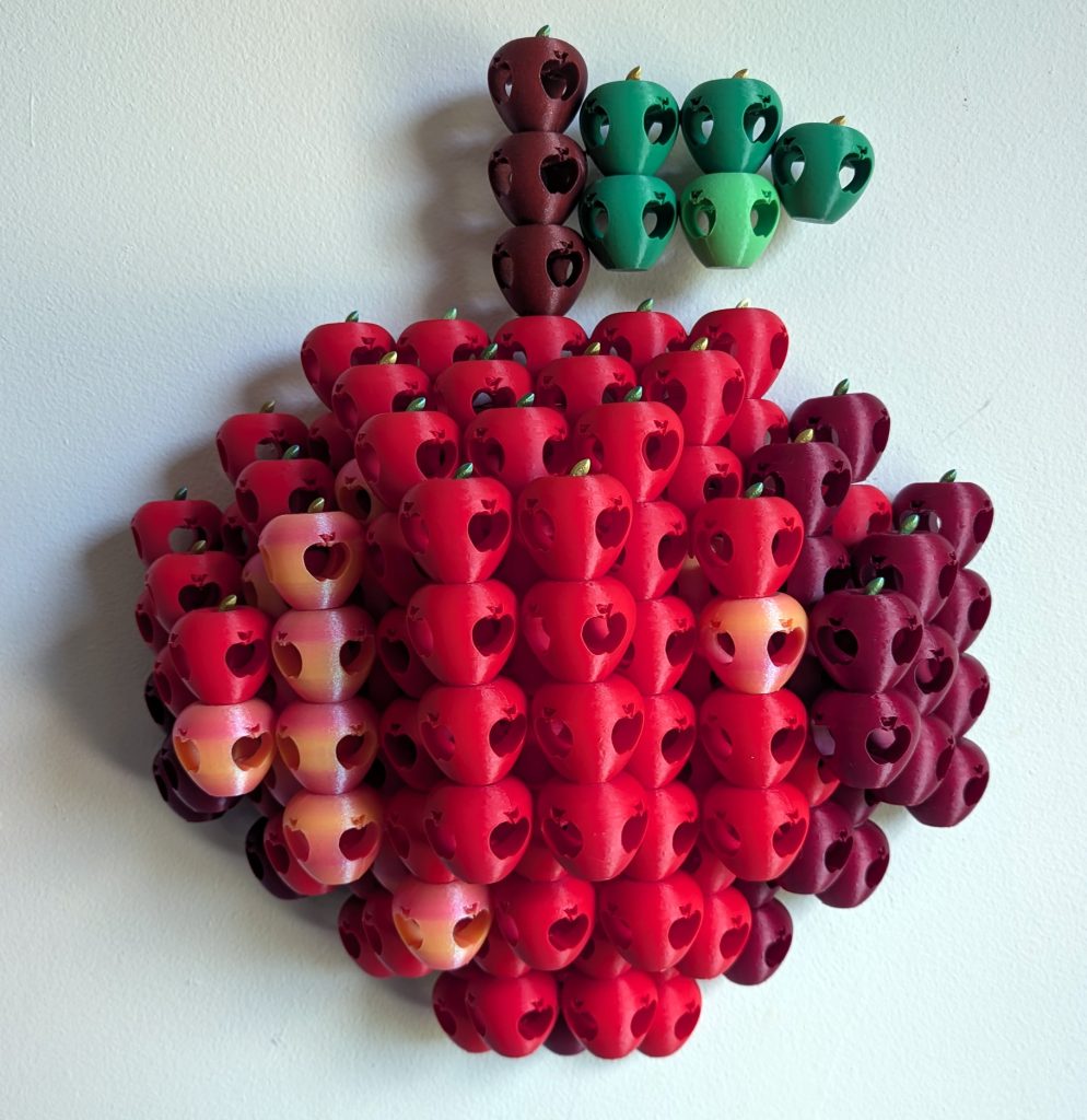 Cultivar. Relief Sculpture of apple made of plastic red apples.
